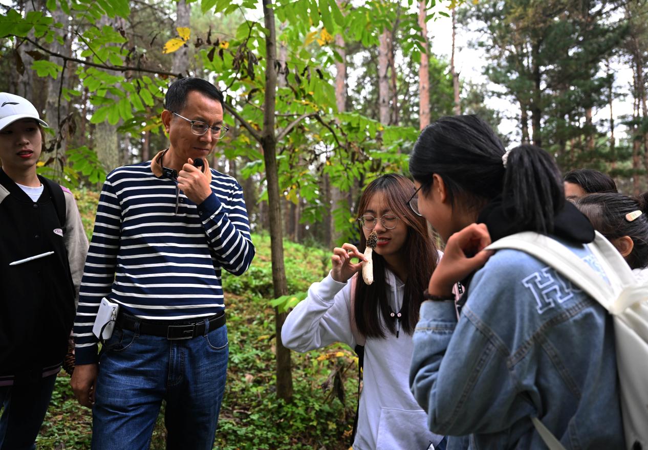 王占斌老師給同學(xué)們講解辨識(shí)蘑菇。（學(xué)校供圖）.jpg