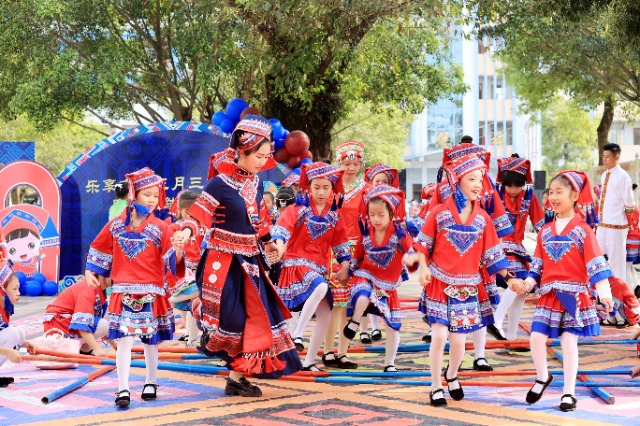 圖4：4月9日，在廣西柳州市融安縣實(shí)驗(yàn)小學(xué)校園，一名老師帶著學(xué)生跳竹竿舞。（譚凱興 攝）.JPG